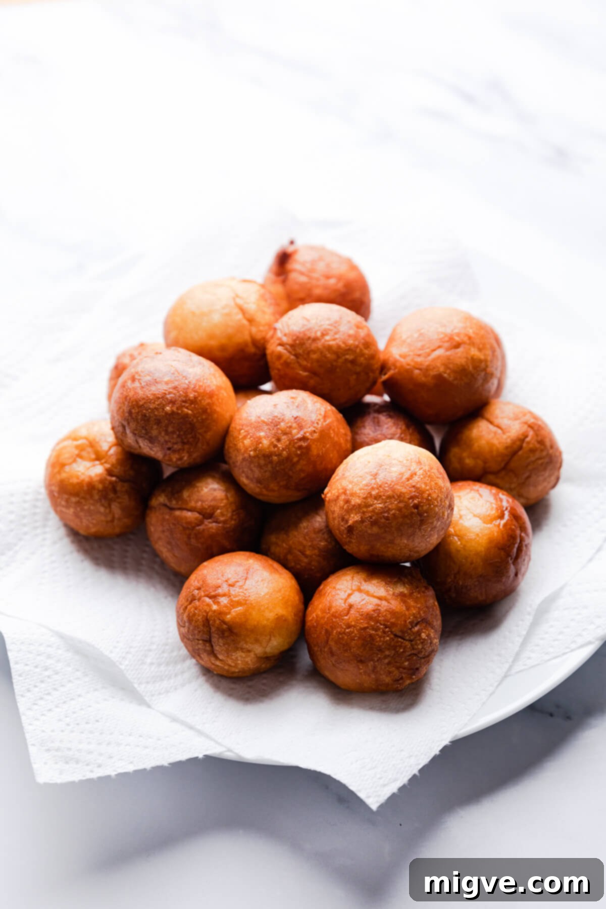 tofu mini doughnuts balls on a plate with paper towel.