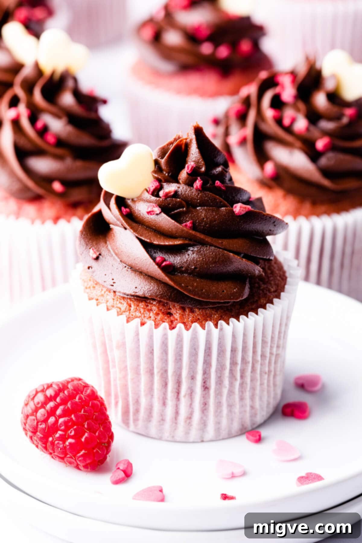 Decadent Raspberry Chocolate Cupcakes 2 chocolate and raspberry cupcake on a small white plate, showcasing the rich chocolate buttercream and a hint of raspberry flavor.