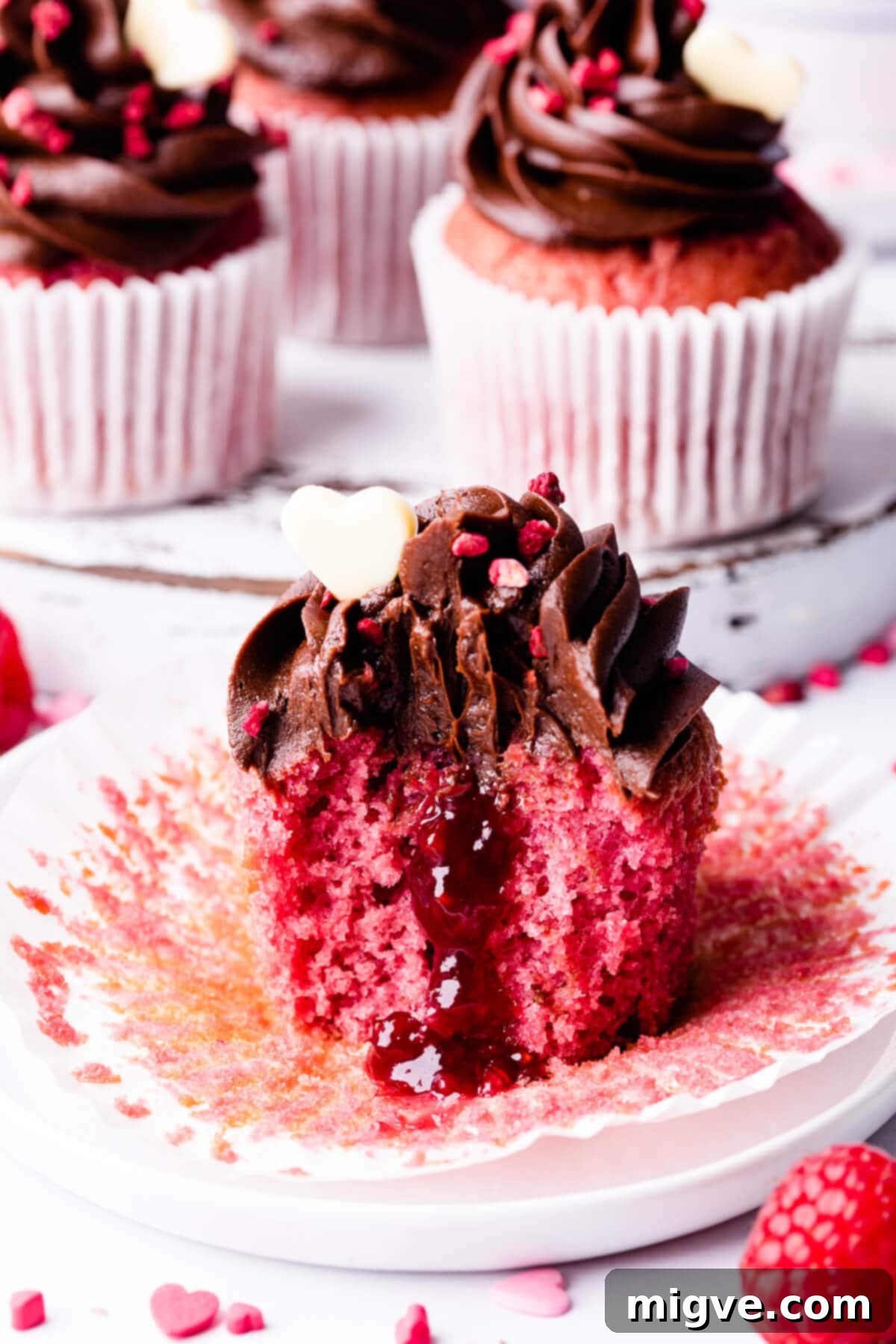 Decadent Raspberry Chocolate Cupcakes 11 raspberry filled cupcake with bite taken out, showing the jam centre and soft sponge.