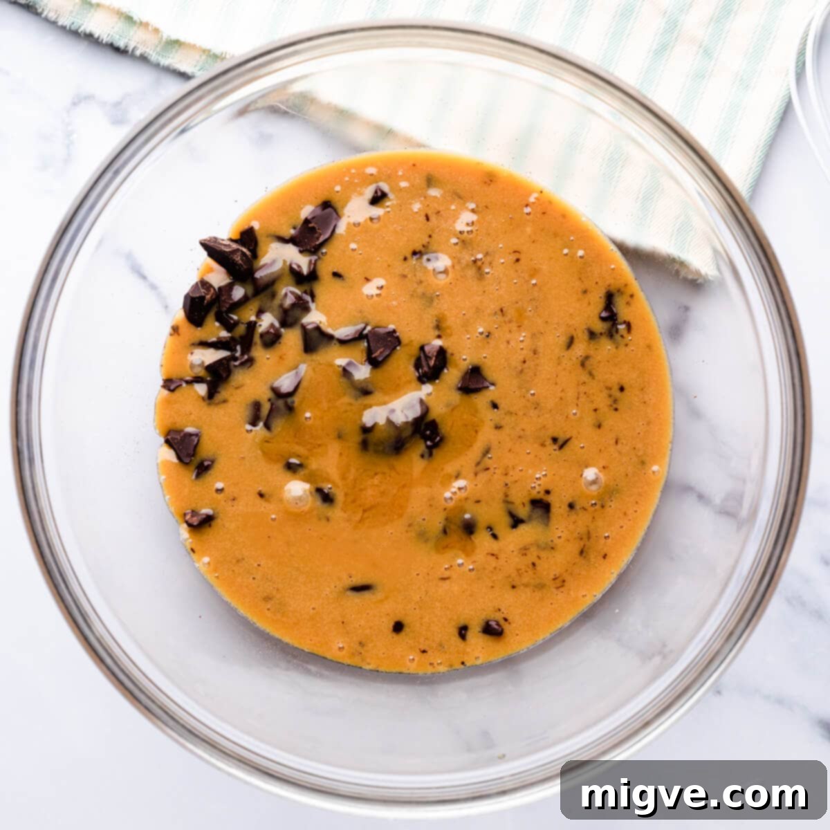 glass bowl with chopped chocolate covered with hot cream and caramel mixture.