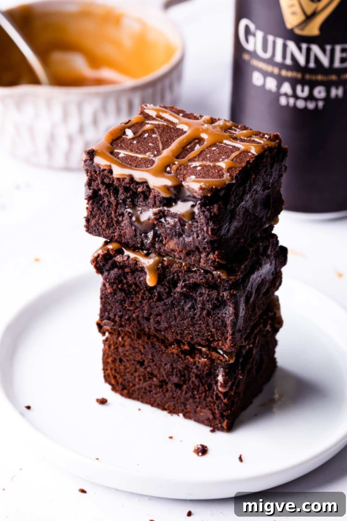 stack of Guinness brownies on a white dessert plate with can of Guinness behind it.