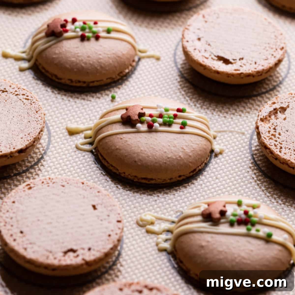 Ginger macaron shells elegantly drizzled with melted white chocolate and adorned with festive sprinkles.