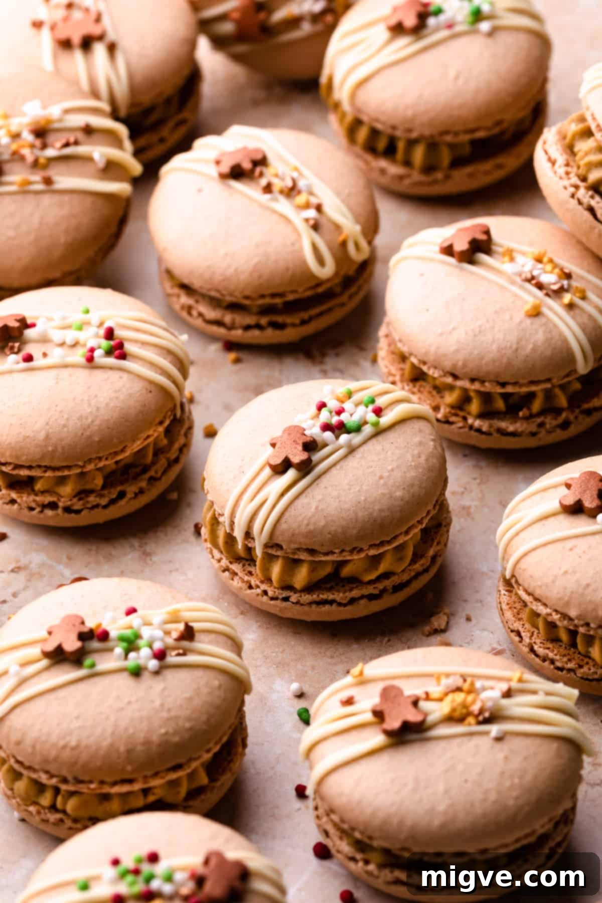 Christmas gingerbread macarons beautifully drizzled with white chocolate and adorned with festive sprinkles on top.