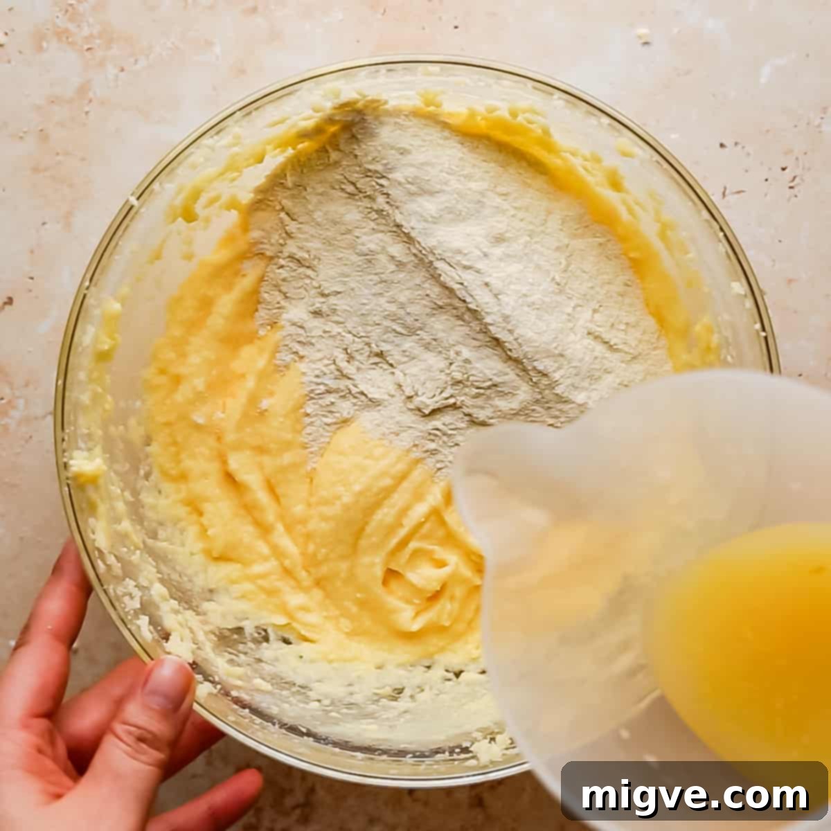 dry ingredients being added to bowl with wet ingredients and lemon juice being added.