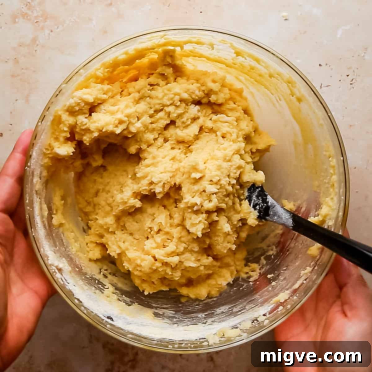 bowl with cake batter for lemon semolina cake and spatula inside of the bowl.