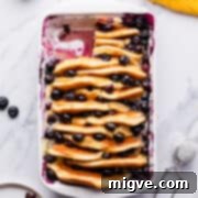 Baked Blueberry Pancake Bliss 11 Pancake casserole with blueberries and lemon zest inside a white baking dish.