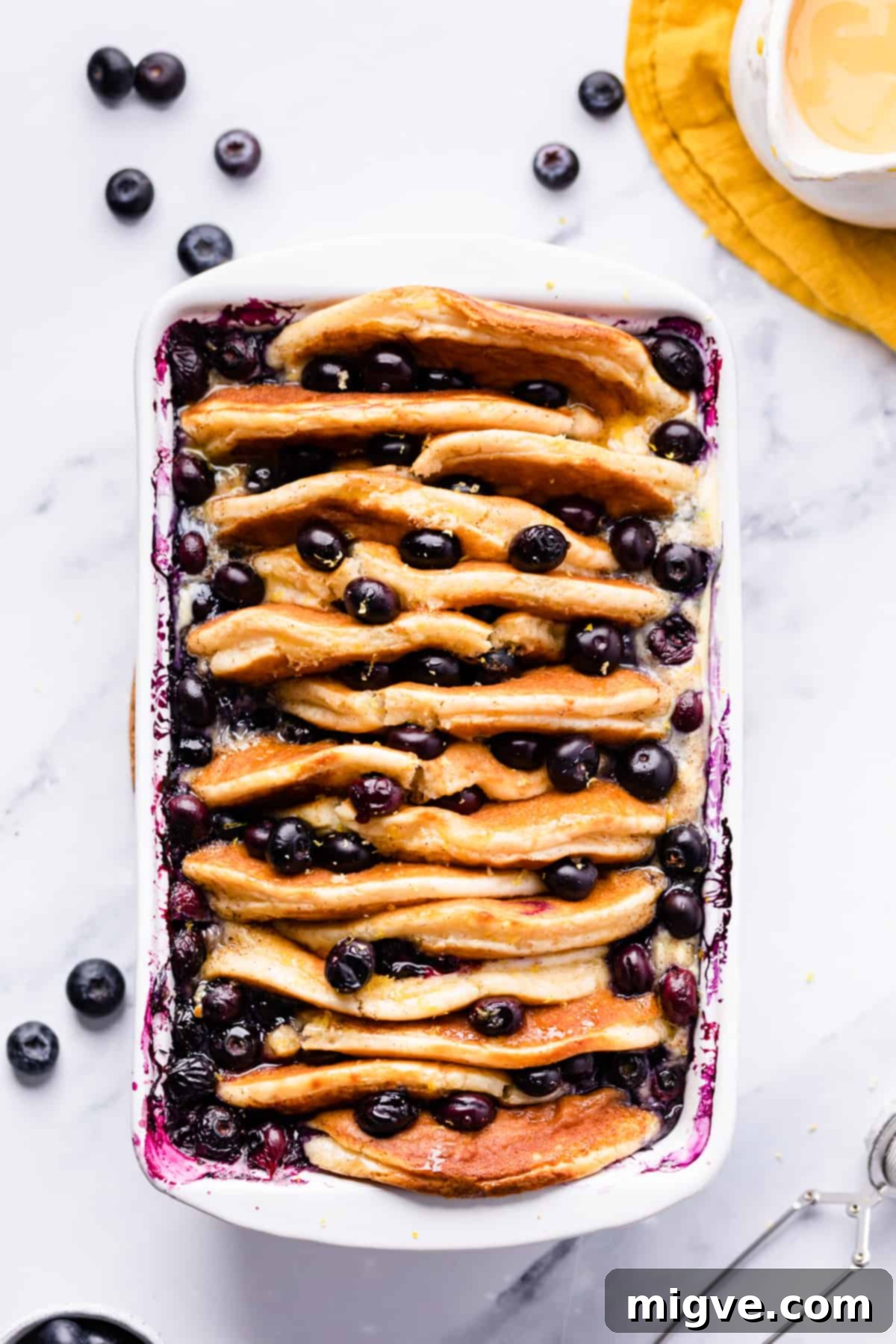 Baked Blueberry Pancake Bliss 8 White rectangular ceramic baking dish with blueberry pancake pudding inside, beautifully baked.