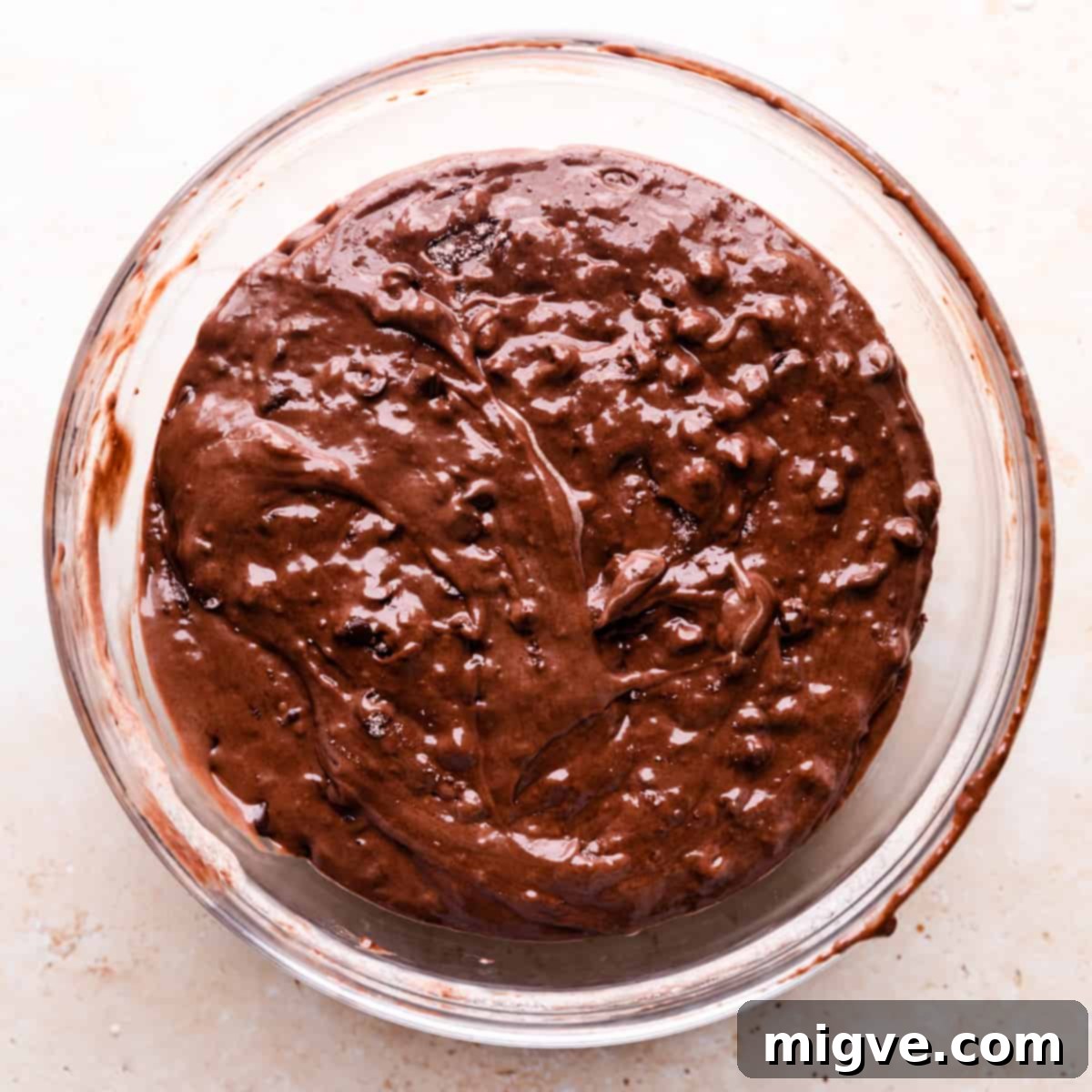 A large bowl holding the rich, dark batter for chocolate muffins, perfectly mixed and ready for baking.