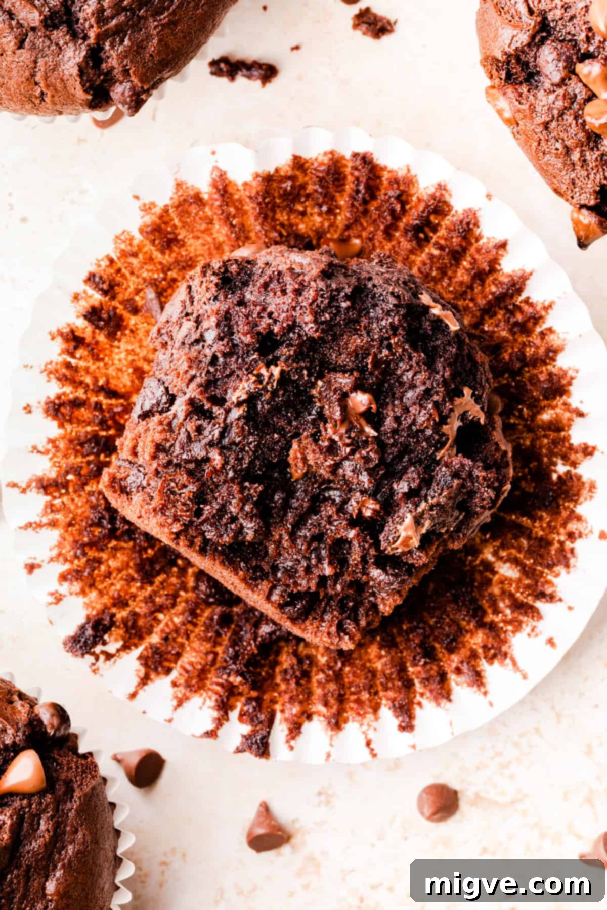 A rich double chocolate muffin with a bite taken out, revealing its incredibly moist and tender crumb texture.