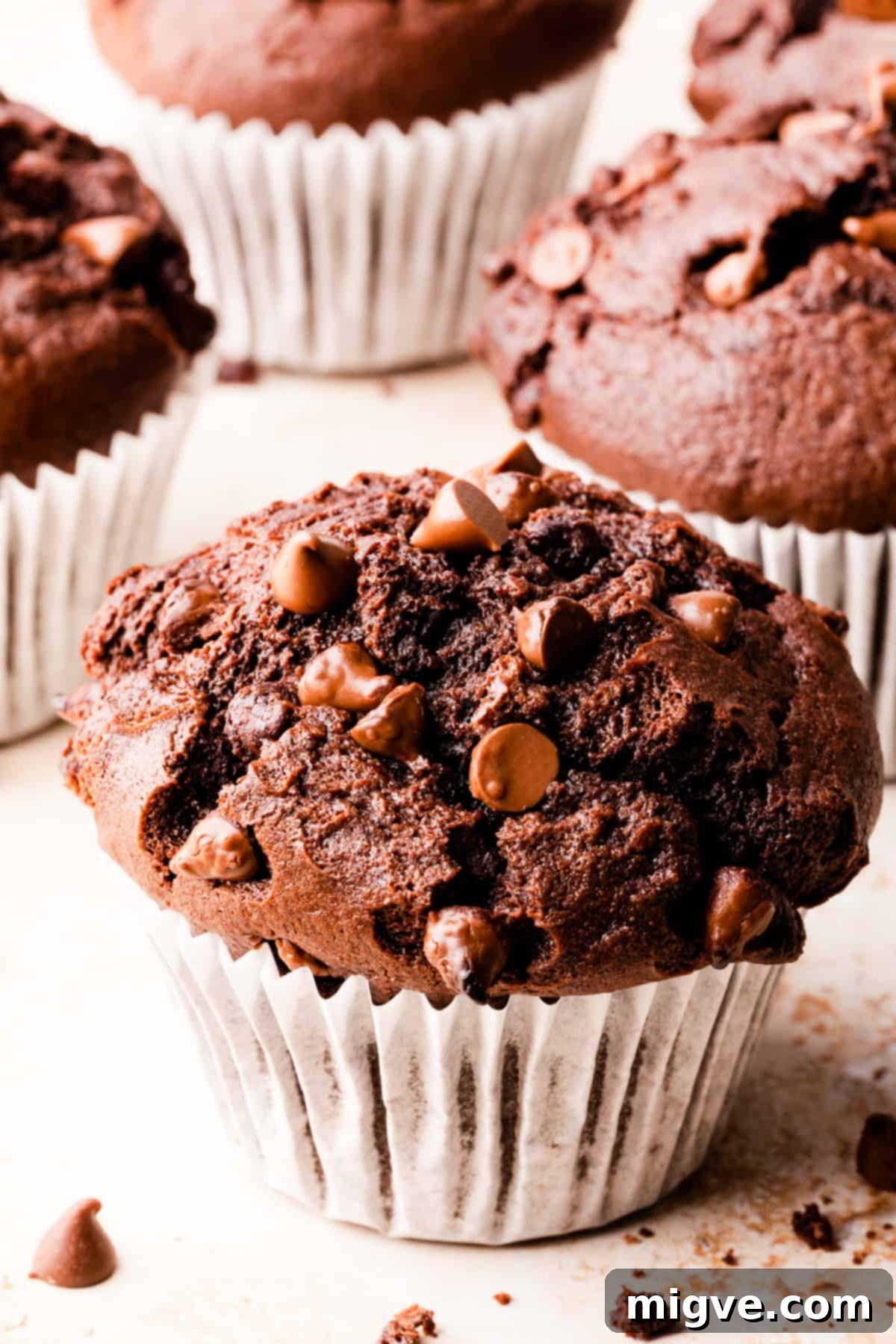 A delectable muffin adorned with chocolate chunks and chocolate chips on top, showcasing its rich texture.