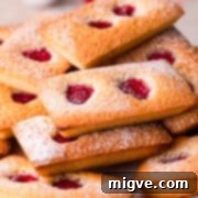 raspberry financiers cakes dusted with sugar and stacked on top of each other.