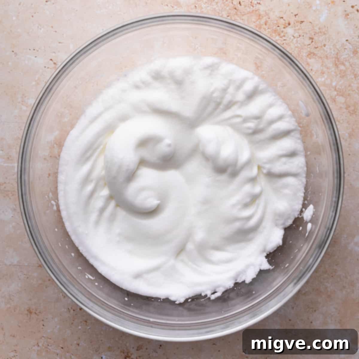 bowl with egg whites whipped into medium peaks.