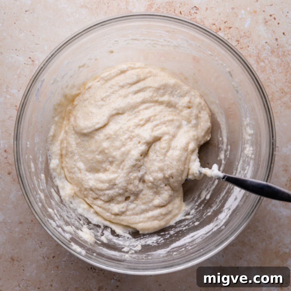 wet and dry ingredients mixed into batter inside of a glass bowl.