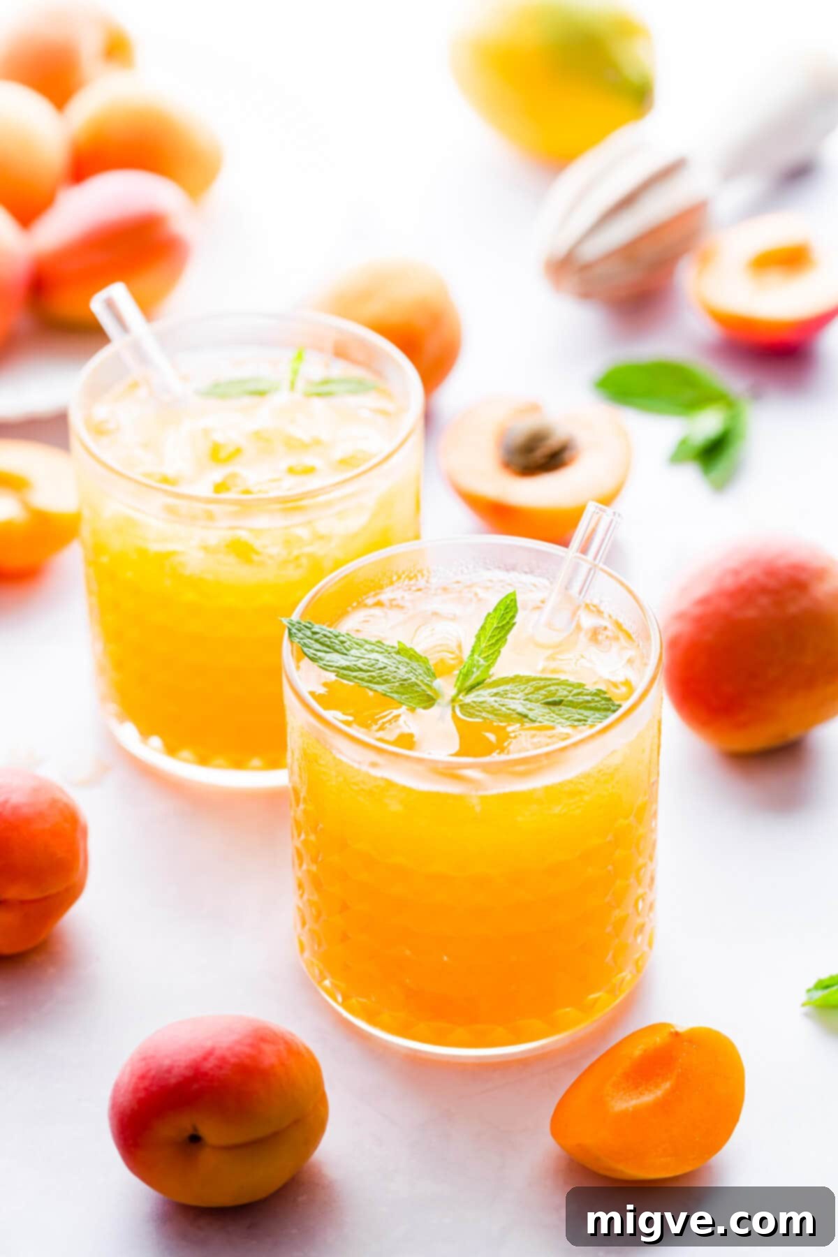 side close up of short tumbler glass filled with crushed ice and apricot nectar