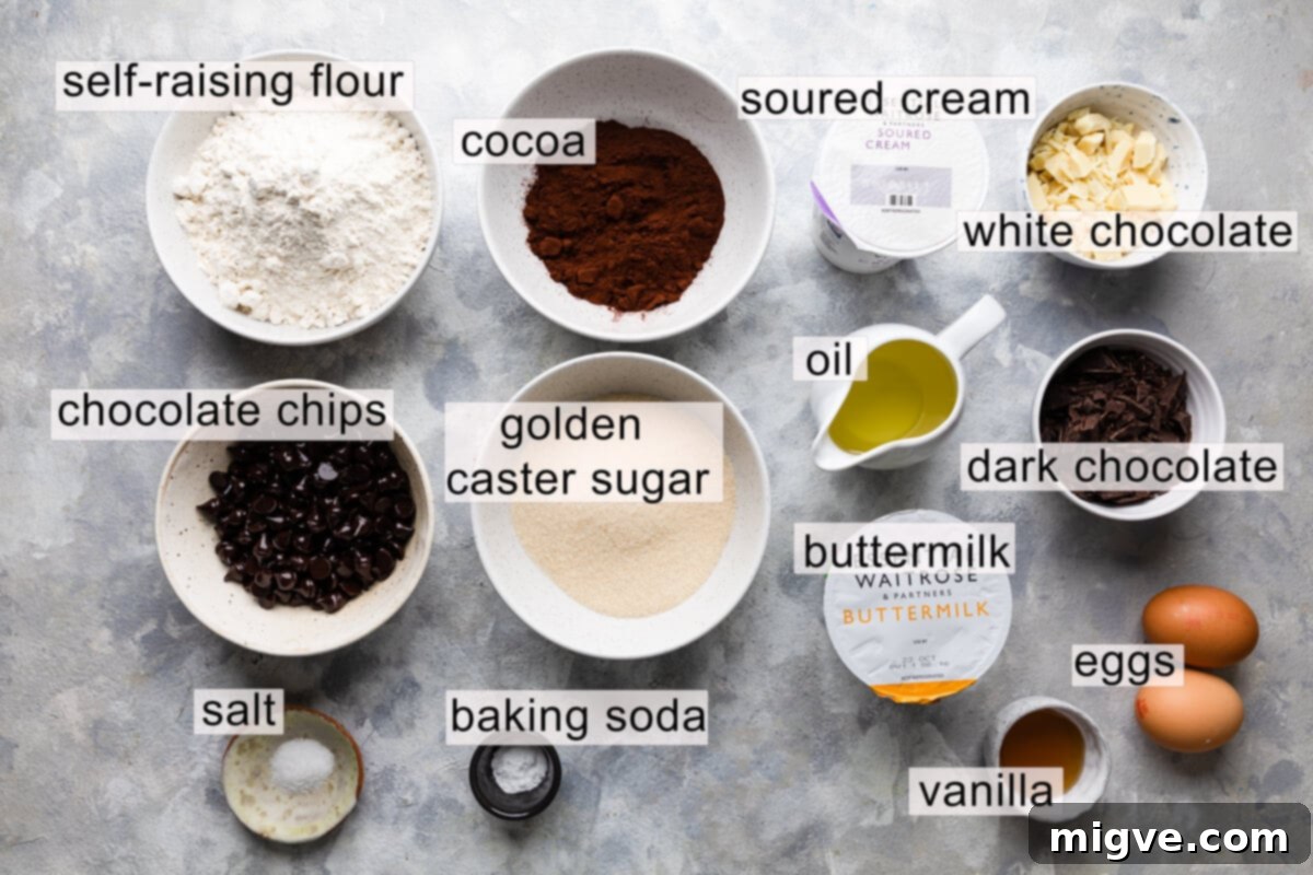 A flat lay photograph displaying all the fresh ingredients for making homemade chocolate fudge muffins, neatly arranged with clear text labels.