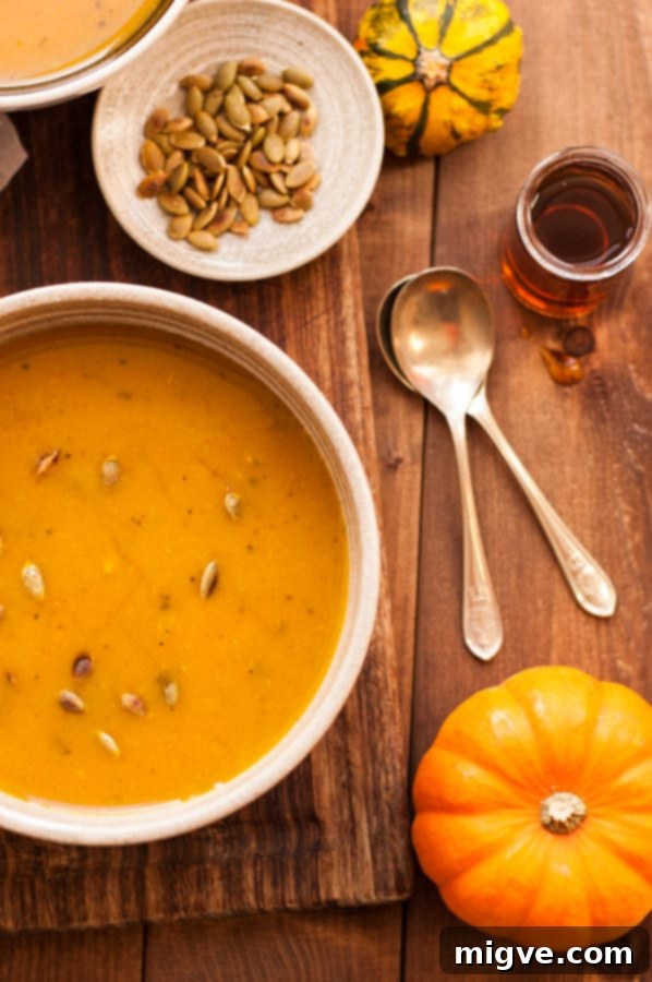 A rustic bowl of golden roasted pumpkin soup, garnished with a sprinkle of fresh pumpkin seeds