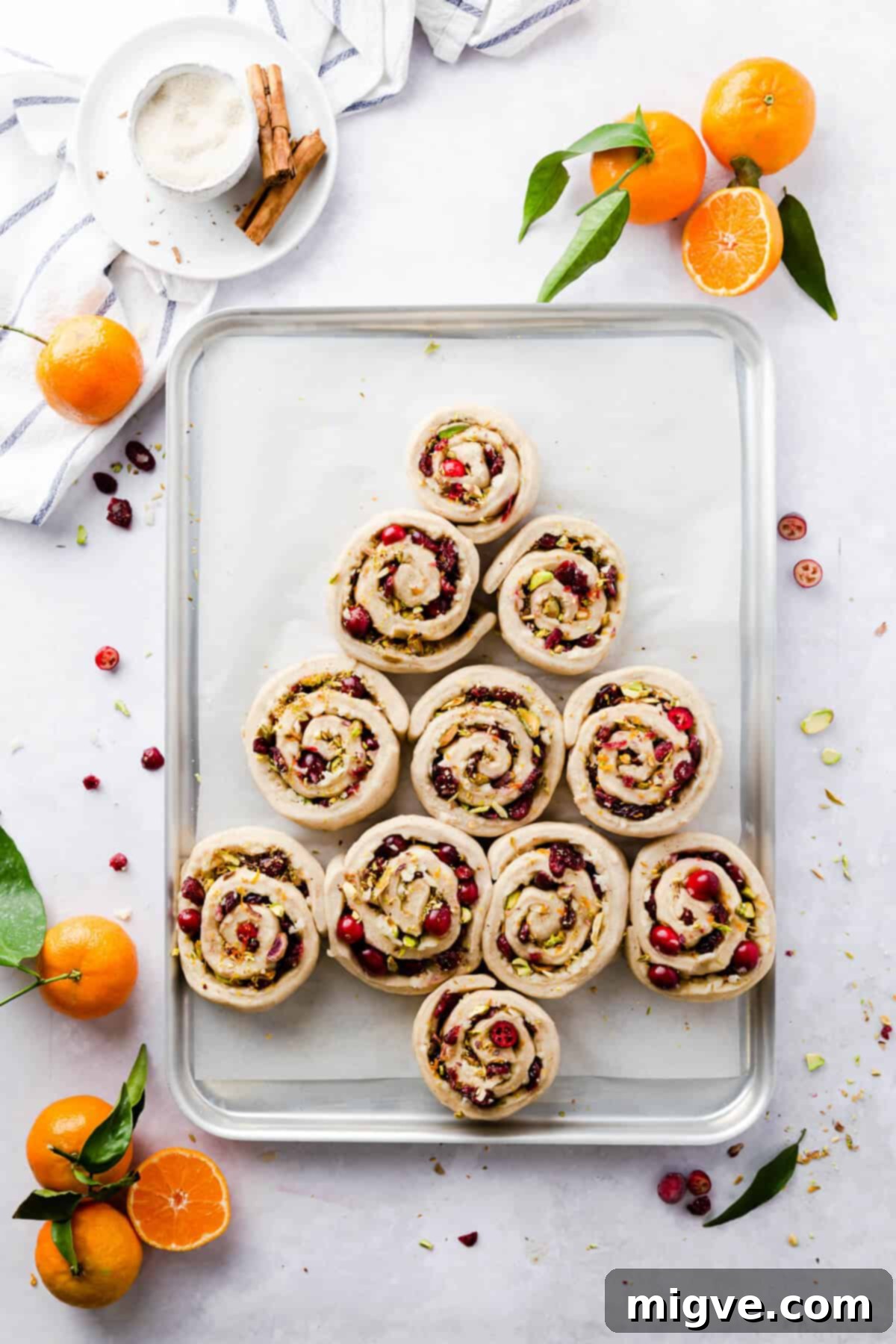 Overhead shot of unbaked Chelsea buns arranged in a Christmas tree shape on a baking tray, ready for their final prove and baking.