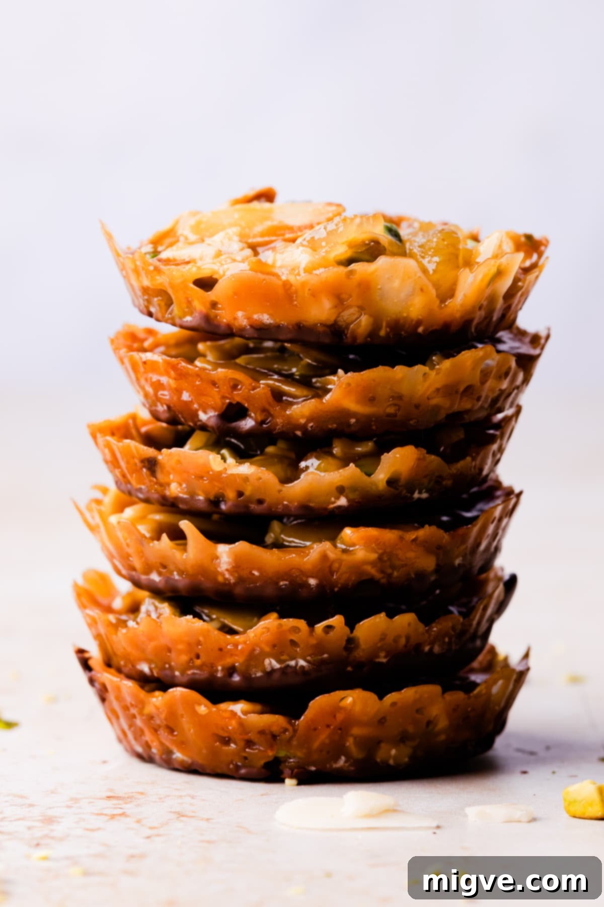 Florentine Almond Lace 17 Stack of six small almond and pistachio florentines, each dipped in rich dark chocolate, showcasing their perfect thickness.