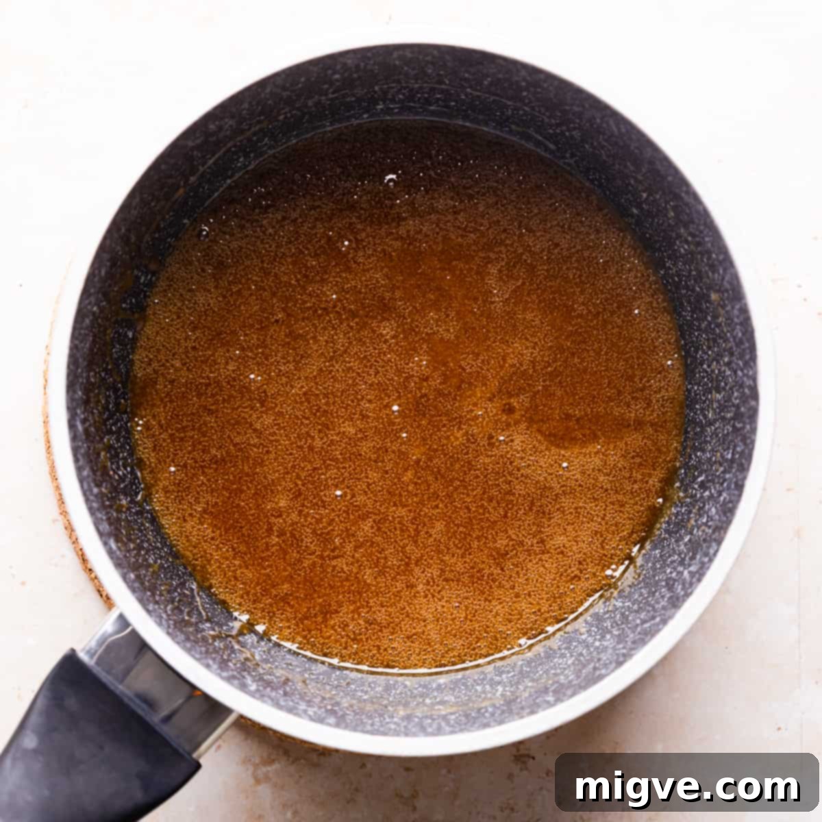 Florentine Almond Lace 4 Small saucepan with melted butter, sugar, and golden syrup mixture inside, beginning the caramel base for florentines.