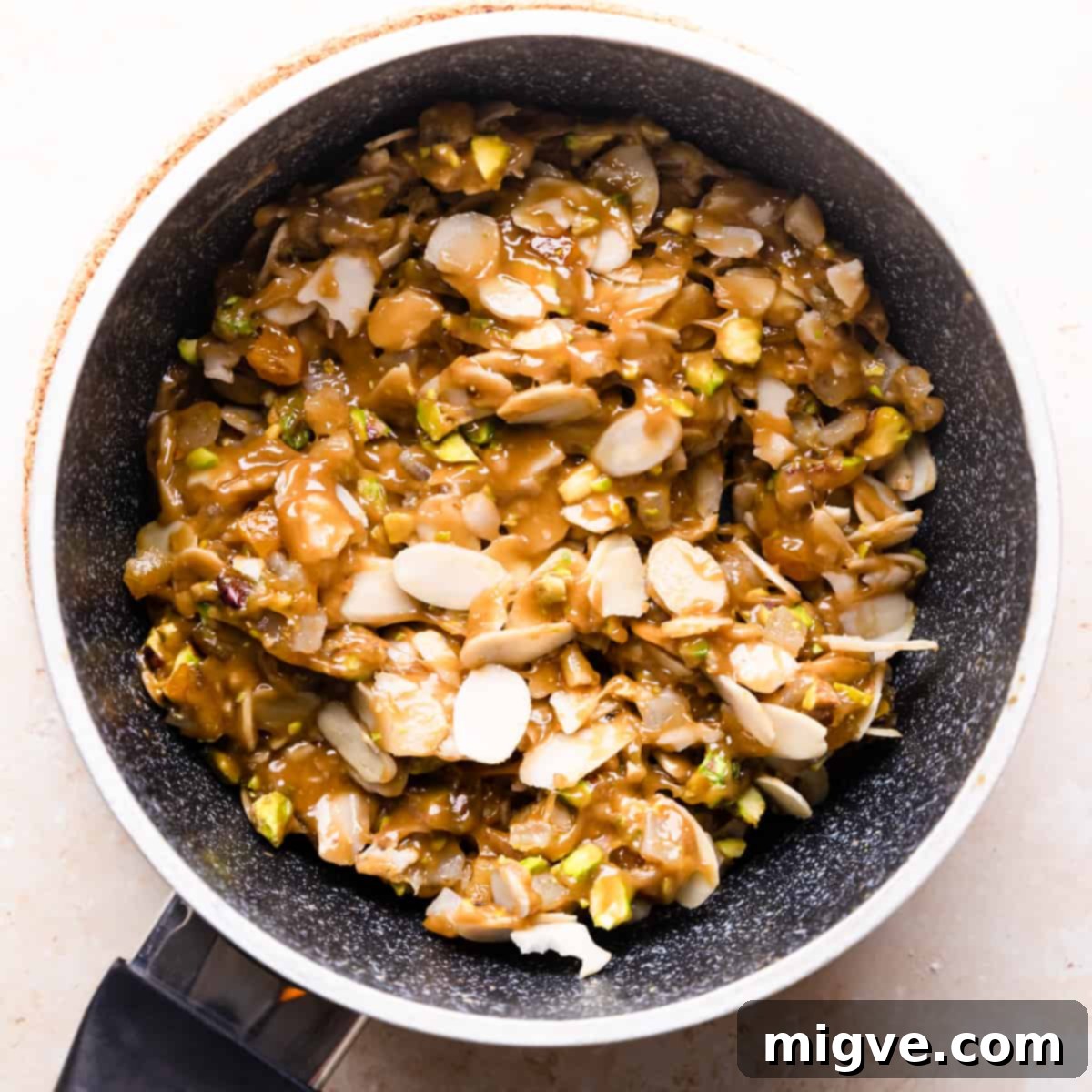 Florentine Almond Lace 6 Saucepan filled with the caramel sauce mixture, now combined with flaked almonds, pistachios, and citrus peel, ready for baking.