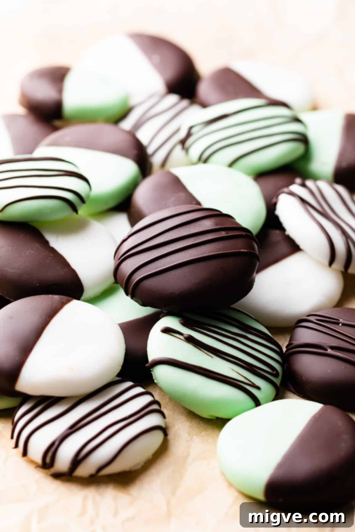 batch of mint creams on brown greaseproof paper where some are drizzled and some are dipped in chocolate.