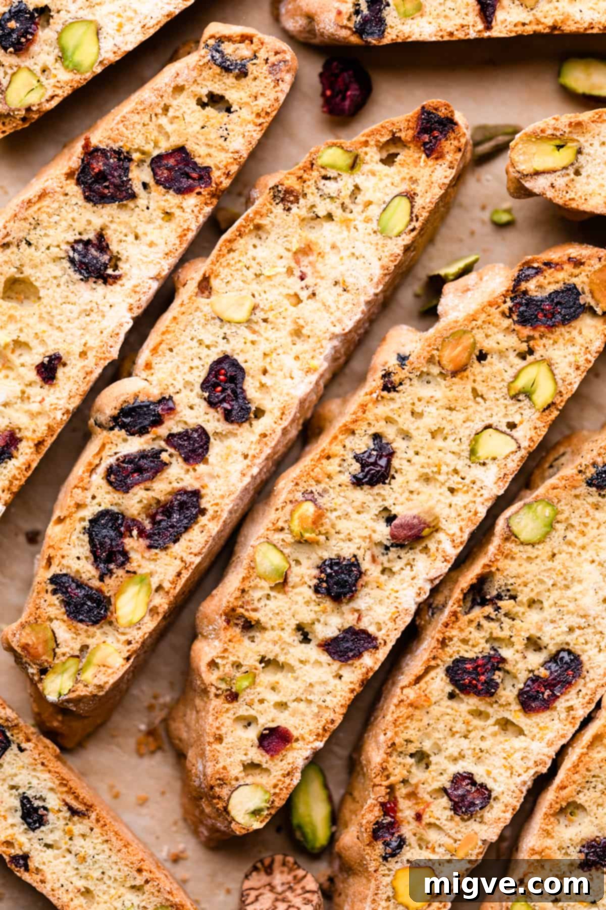 Ruby Red Biscotti 2 biscotti slices stuffed with dried cranberries and pistachios arranged next to each other.