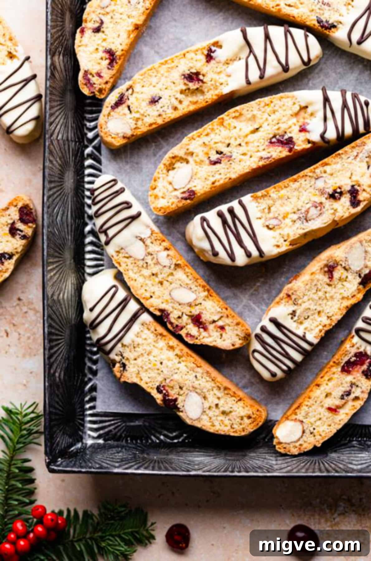 Ruby Red Biscotti 11 cranberry almond biscotti dipped in white chocolate and drizzled with more chocolate inside of the baking tin.