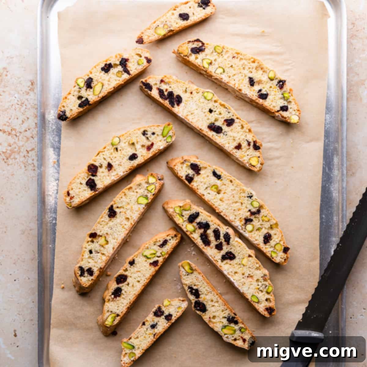 Ruby Red Biscotti 8 cranberry biscotti baked once on top of baking tray with serrated knife on side.