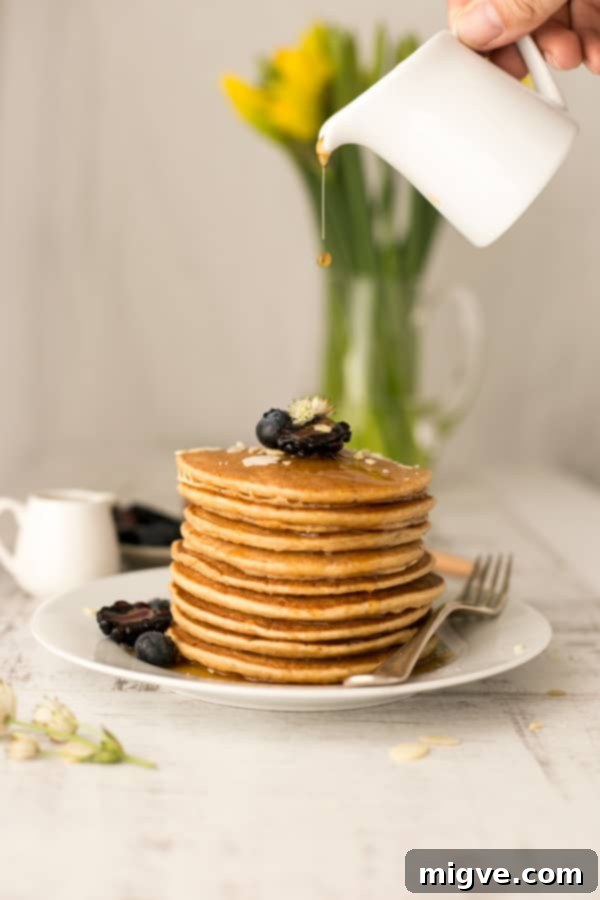 Incredibly delicious & light silken tofu pancakes served with fresh berries and maple syrup, highlighting their fluffy texture