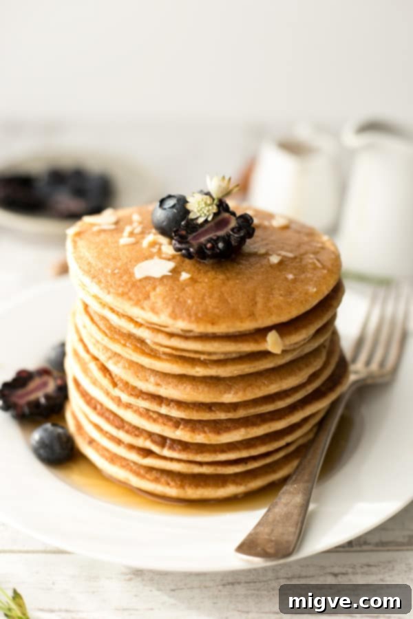 A beautifully arranged plate of breakfast tofu pancakes with maple syrup and berries, ready to be enjoyed