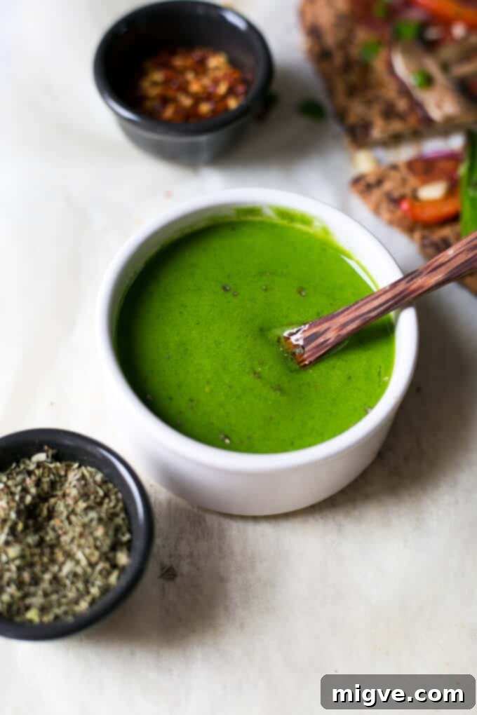 Beautifully prepared Cauliflower Pizza Crust adorned with vibrant asparagus and a fresh spinach dressing, ready to be enjoyed.