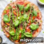Cauliflower Pizza Crust topped with asparagus, showcasing a healthy and delicious meal option.