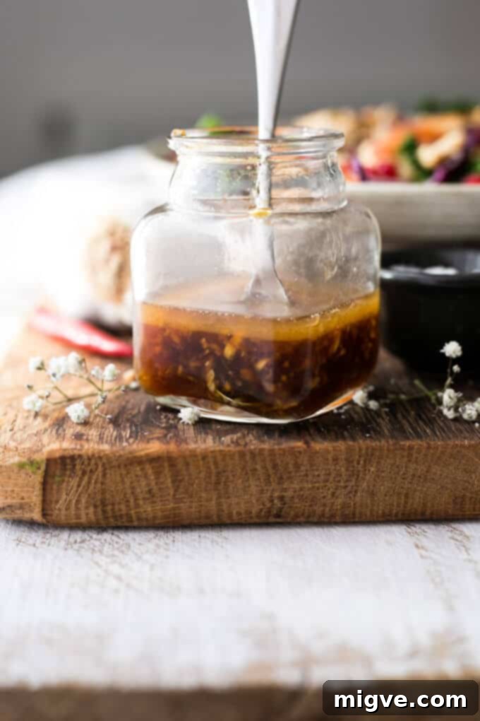 A bowl of fresh Quinoa Stir Fry, showcasing the beautiful mix of red cabbage, carrots, green savoy cabbage, and crunchy cashews.