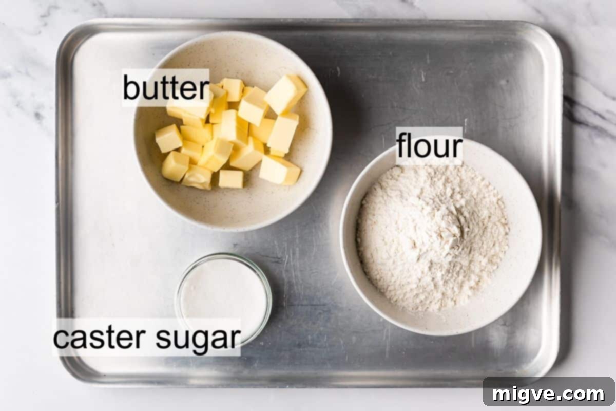 Bowls of flour, butter, and sugar, ready for making Scottish shortbread biscuits, on a metal tray.