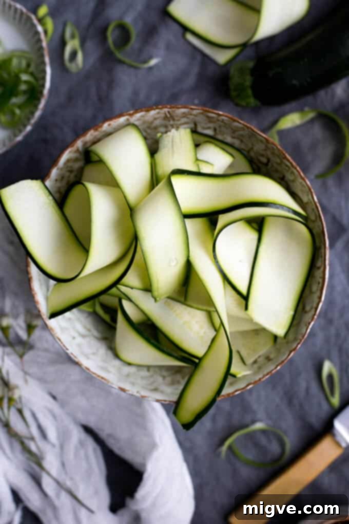 A vibrant bowl of sticky tofu, tender noodles, and a refreshing zucchini salad, perfect for a healthy dinner