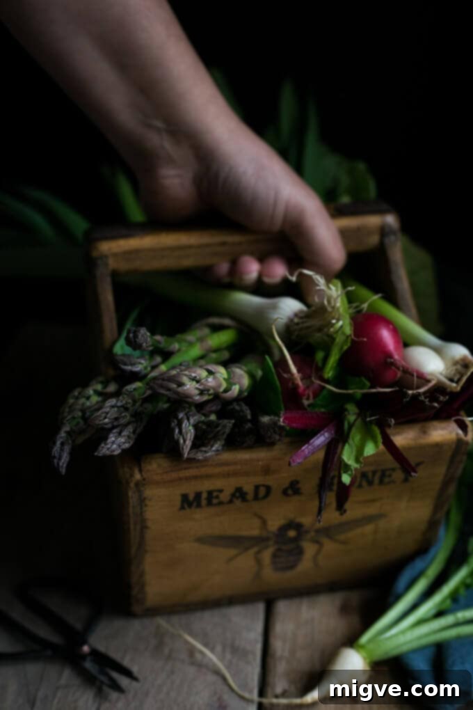 Close-up of Charred asparagus tart with baby leeks and peas, showcasing vibrant spring ingredients.