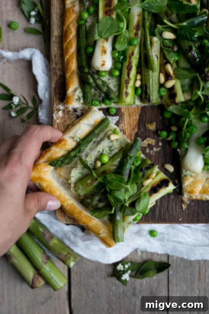 Charred asparagus tart made with butter bean paste and spring greens, served elegantly.