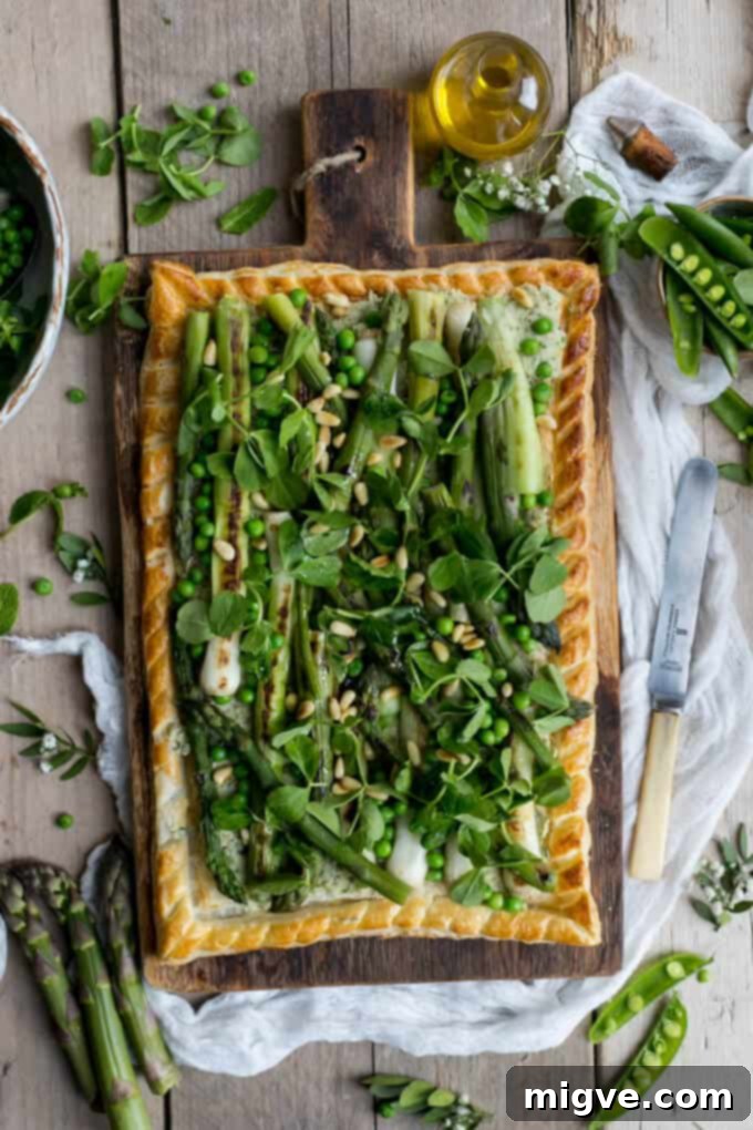 Charred asparagus tart with butter bean paste, pea shoots, baby leeks and pine nuts, a vibrant and healthy dish.