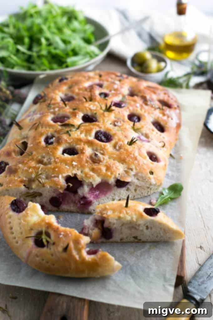 Delicious rosemary focaccia bread with sweet red grapes and flaky sea salt, perfect for summer picnics