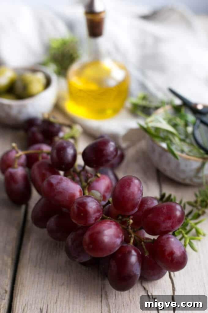 Homemade rosemary focaccia with sea salt and juicy red grapes, a rustic Italian bread