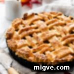 A tantalizing side close-up of a freshly baked apple pie with a beautiful lattice top, golden-brown and flaky, inviting a warm bite.