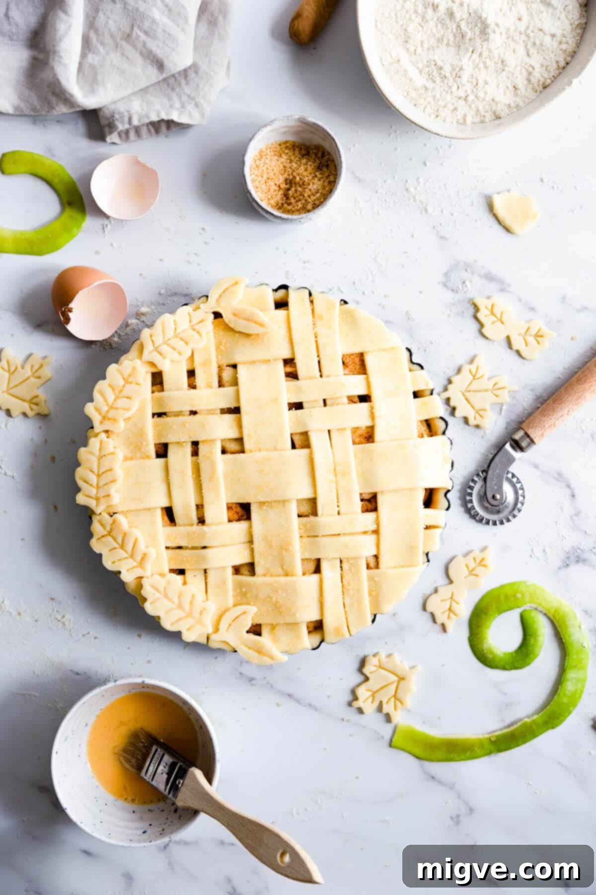 Top-down view of an unbaked apple pie, showcasing a beautifully intricate lattice top, ready for the oven, resting in a ceramic pie dish.