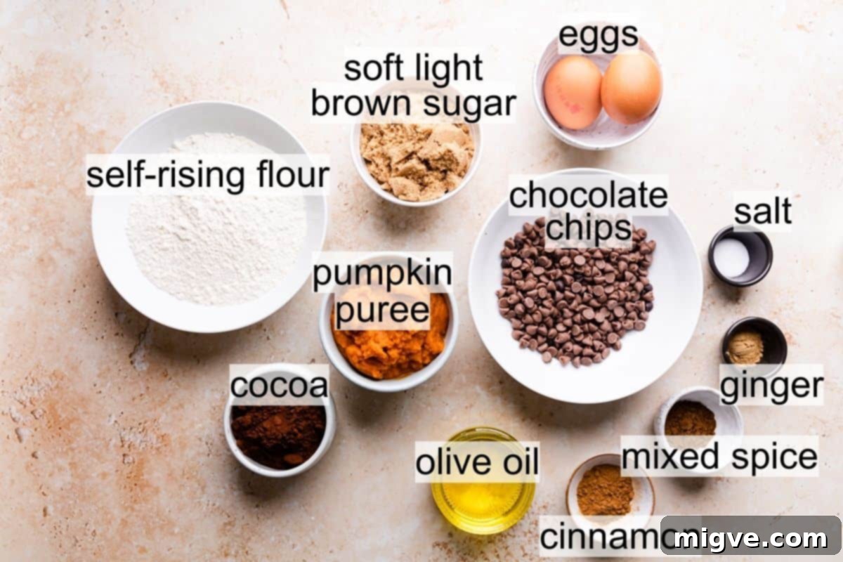 Bowls filled with dry and wet ingredients for making chocolate pumpkin bread, showcasing the rich colors of pumpkin puree and cocoa.