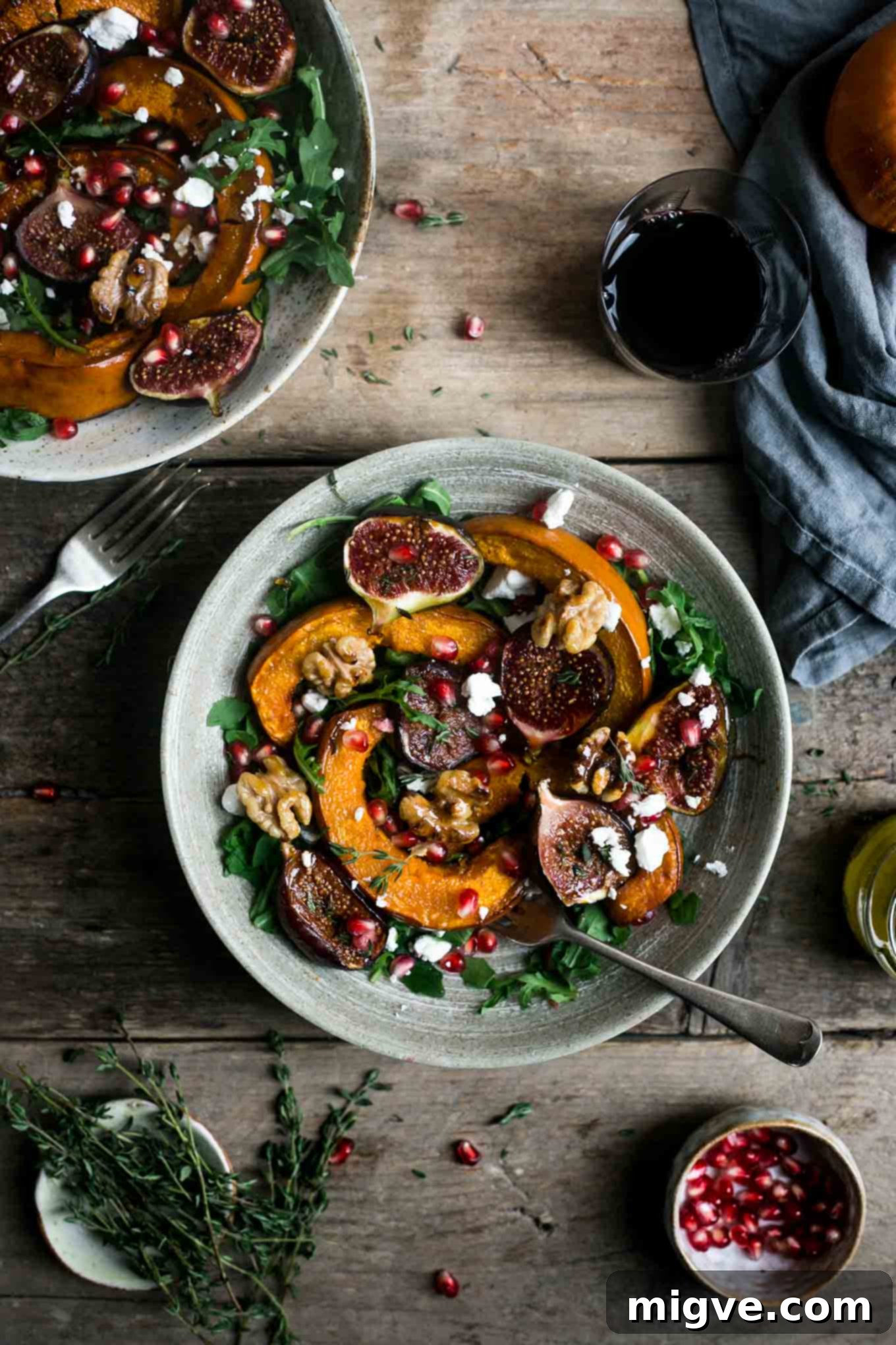 A beautifully arranged seasonal salad featuring roasted pumpkin and walnuts, emphasizing its vegan attributes and freshness.