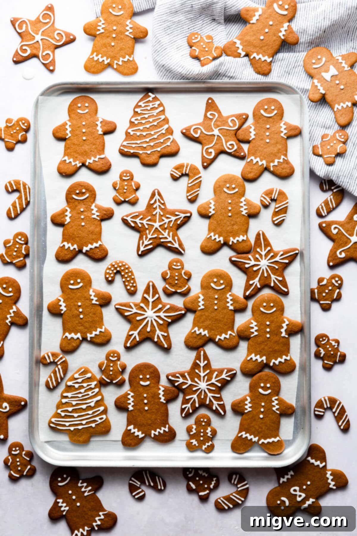 Pillowy Soft Gingerbread Cookies 2 Overhead shot of soft gingerbread cookies, beautifully decorated with white icing, resting on a rustic baking sheet, ready for the holidays.