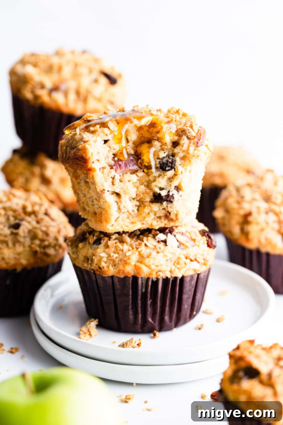 straight ahead super close up at a stack of two apple muffins with top one drizzled with honey