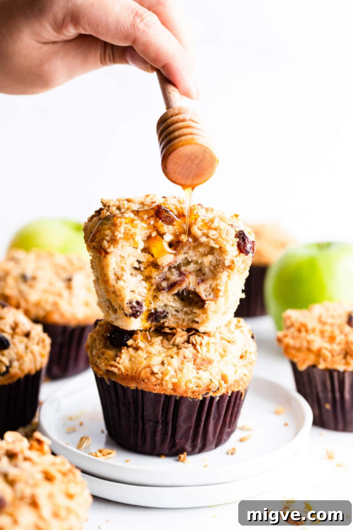 side super close up at a stack of two muffins being drizzled with honey